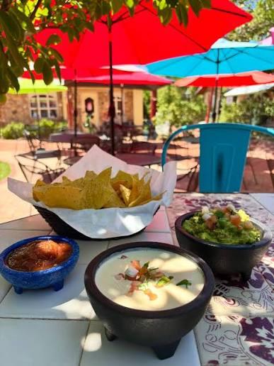 Chips, salsa, queso and guacamole on a sunny patio